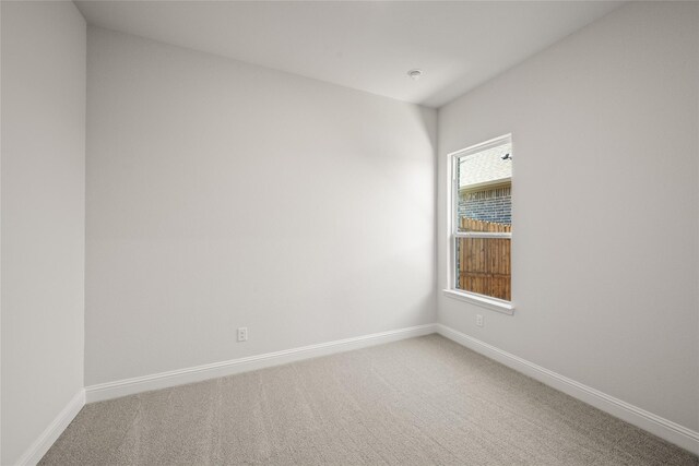 unfurnished room with baseboards and carpet