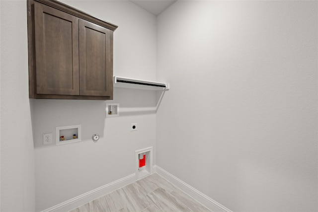 laundry area featuring cabinet space, washer hookup, hookup for a gas dryer, electric dryer hookup, and baseboards