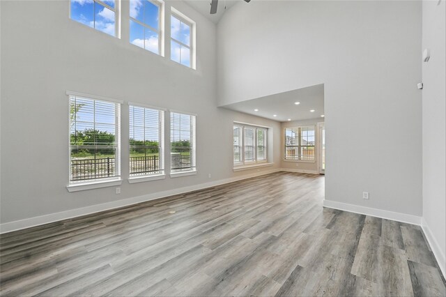 1000 Tulip Pl, Crowley, TX 76036 - unfurnished living room with ceiling fan, wood finished floors, a towering ceiling, and baseboards