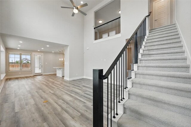 1000 Tulip Pl, Crowley, TX 76036 - stairway featuring a ceiling fan, wood finished floors, baseboards, recessed lighting, and a high ceiling