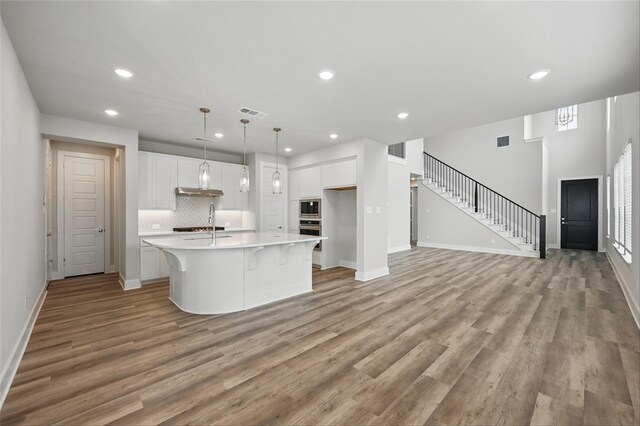 1000 Tulip Pl, Crowley, TX 76036 - kitchen with stainless steel appliances, light countertops, white cabinets, recessed lighting, and light wood-type flooring