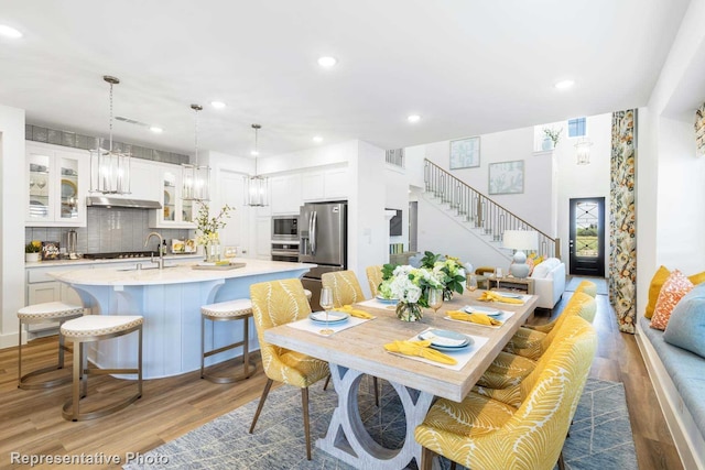 dining area featuring stairs, recessed lighting, visible vents, and wood finished floors