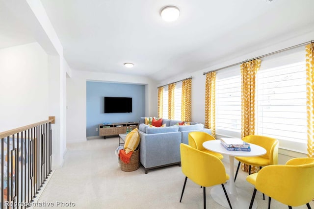 dining space with baseboards and light carpet