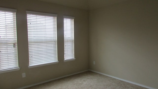carpeted spare room with baseboards