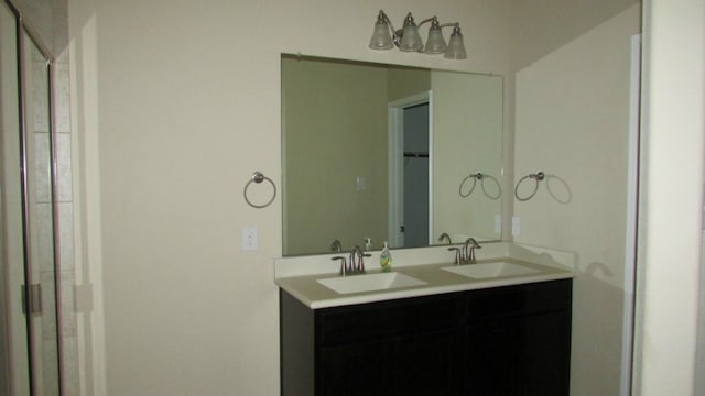 full bath with a sink, double vanity, and a spacious closet