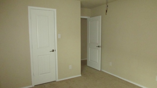unfurnished bedroom featuring baseboards and carpet flooring