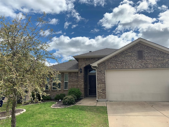 ranch-style house featuring a front yard, roof with shingles, brick siding, an attached garage, and driveway