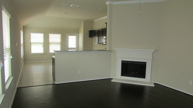 unfurnished living room with baseboards, tile patterned flooring, a fireplace with raised hearth, and vaulted ceiling