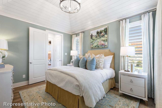 bedroom featuring baseboards, wooden ceiling, and light wood finished floors