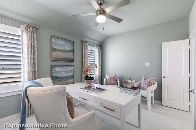 home office featuring baseboards, a ceiling fan, vaulted ceiling, and light carpet