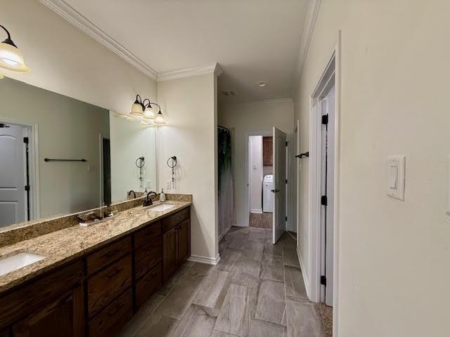 bathroom featuring crown molding, a sink, baseboards, and double vanity