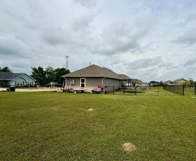 back of property with fence and a lawn