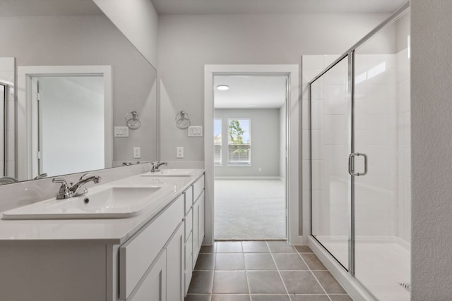 bathroom with tile patterned flooring, a sink, a stall shower, and double vanity