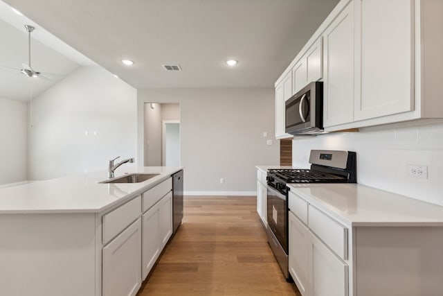 kitchen featuring visible vents, light wood-style floors, ceiling fan, a sink, and stainless steel appliances