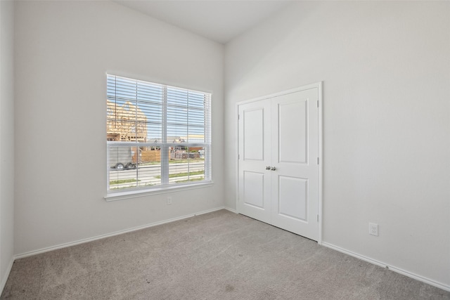 unfurnished bedroom with baseboards, carpet, and a closet