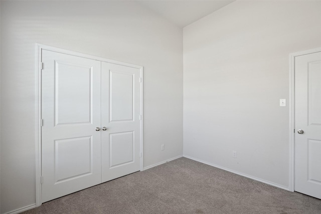 unfurnished bedroom with baseboards, carpet, and a closet