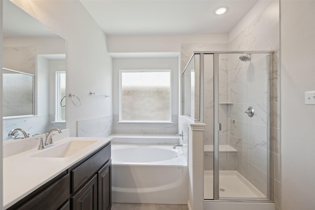 bathroom with vanity, a stall shower, and a garden tub