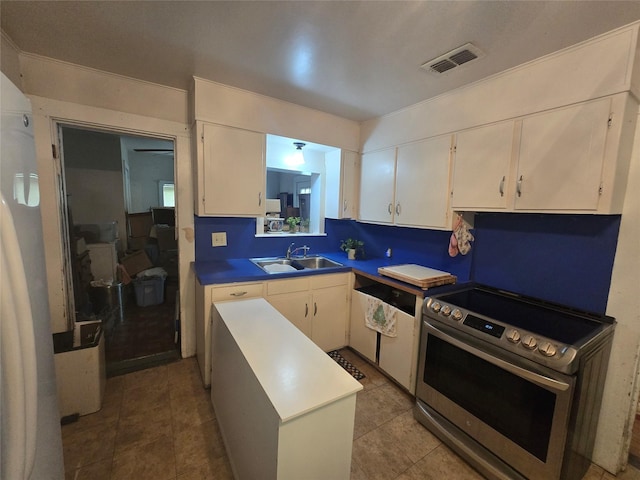 kitchen featuring a sink, white cabinets, electric range, and visible vents