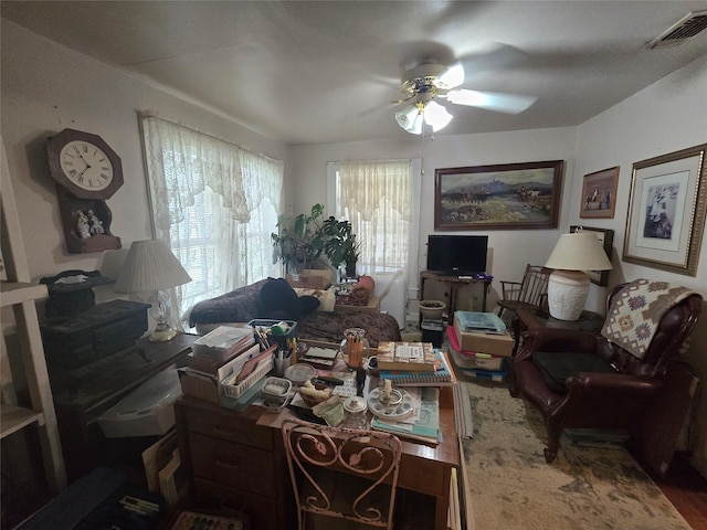 living room featuring a ceiling fan and visible vents