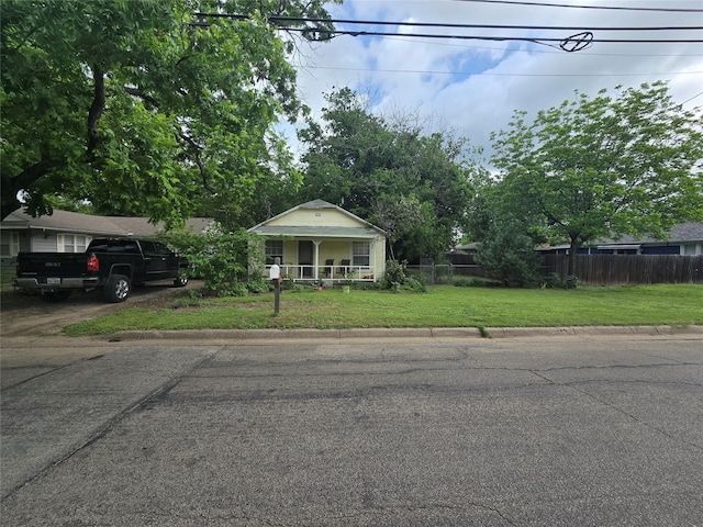 bungalow-style home featuring fence private yard, covered porch, and a front yard