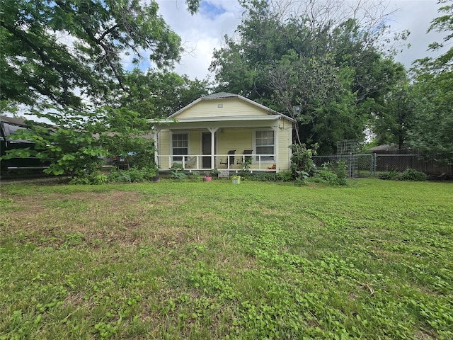 bungalow with a porch, a front lawn, and fence