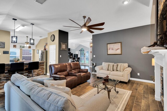 living area with visible vents, wood finished floors, lofted ceiling, baseboards, and a ceiling fan