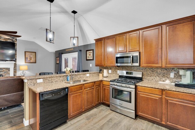 kitchen with a sink, stainless steel appliances, open floor plan, a peninsula, and vaulted ceiling