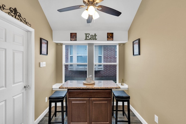 dining space with vaulted ceiling, baseboards, and a ceiling fan