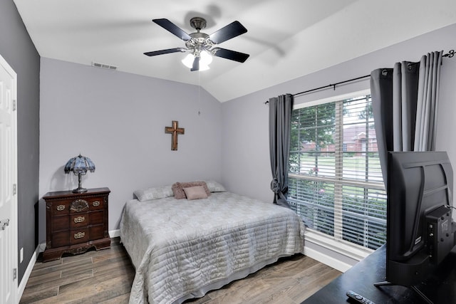 bedroom featuring baseboards, wood finished floors, and visible vents