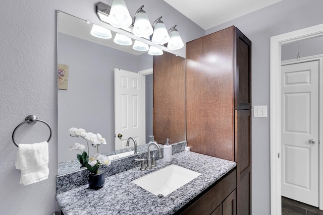 bathroom featuring a notable chandelier and vanity