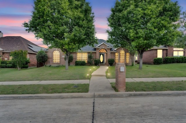 view of front of house featuring brick siding and a front yard