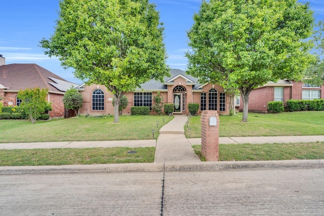 view of front of property featuring brick siding and a front lawn