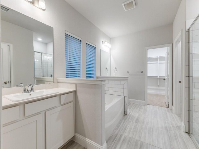full bath featuring an enclosed shower, a walk in closet, a bath, and visible vents
