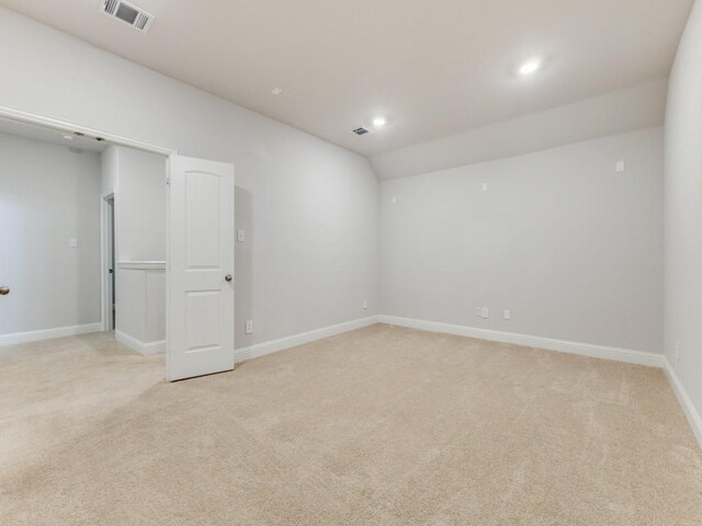 empty room featuring baseboards, light colored carpet, and visible vents