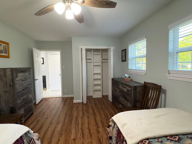 bedroom featuring baseboards, a ceiling fan, wood finished floors, and a closet