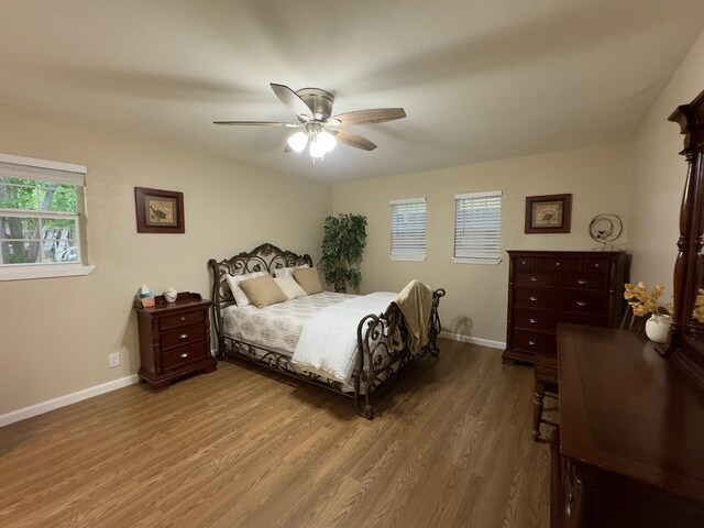 bedroom featuring baseboards, a ceiling fan, and wood finished floors