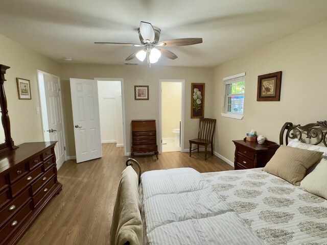 bedroom with a ceiling fan, baseboards, wood finished floors, and ensuite bath