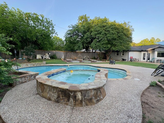 view of pool featuring a patio, a fenced backyard, an in ground hot tub, and a fenced in pool