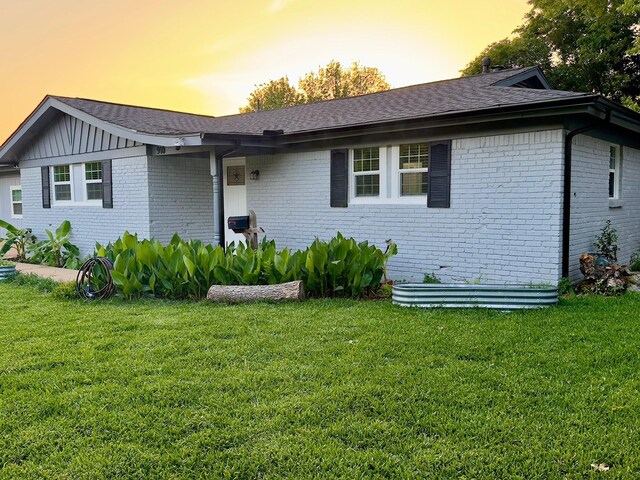 view of front of home with a front yard and brick siding