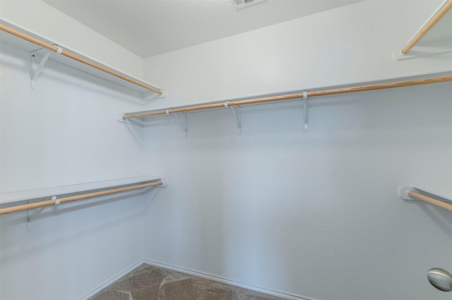 spacious closet featuring dark colored carpet