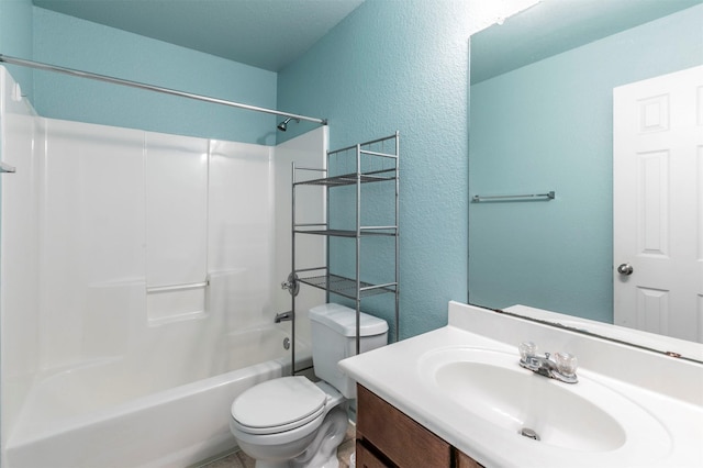 bathroom with vanity, a textured wall, bathing tub / shower combination, and toilet