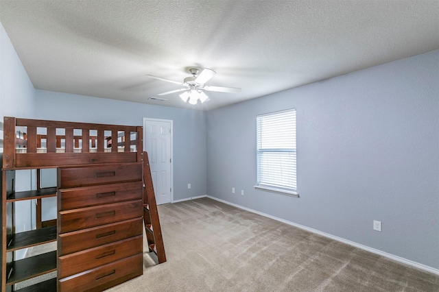 unfurnished bedroom featuring a textured ceiling, baseboards, visible vents, and carpet