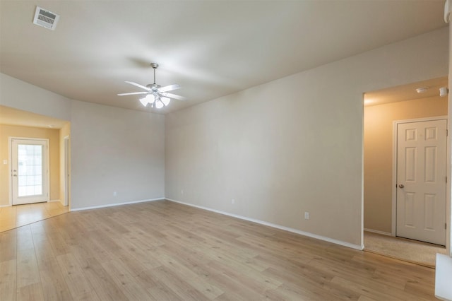 empty room featuring visible vents, light wood finished floors, ceiling fan, and baseboards