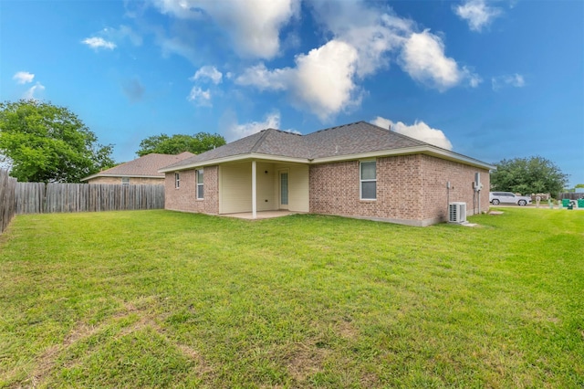 back of property featuring brick siding, a patio, fence, and a lawn