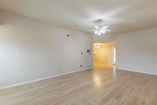 empty room with visible vents, light wood-style flooring, ceiling fan, and baseboards