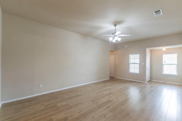 empty room with baseboards, light wood finished floors, and ceiling fan