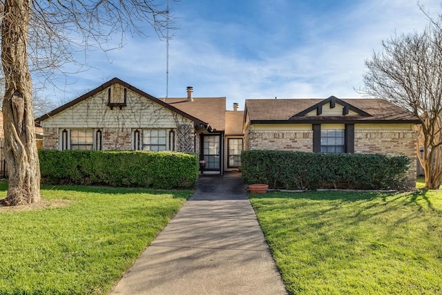 view of front of house featuring brick siding and a front lawn