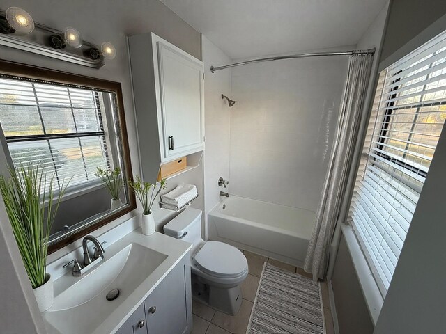 bathroom featuring vanity, a wealth of natural light, tile patterned flooring, and shower / tub combo