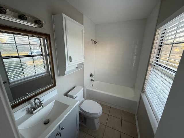 full bathroom featuring toilet, bathing tub / shower combination, a healthy amount of sunlight, and tile patterned flooring