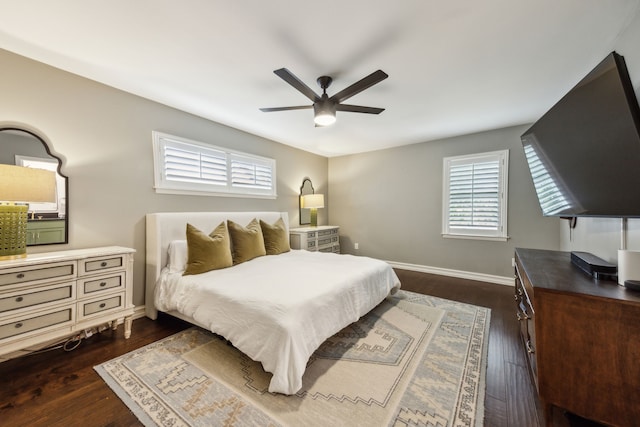 bedroom featuring baseboards, a ceiling fan, and dark wood finished floors